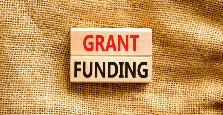 Grant Funding Symbol. Concept Words Grant Funding On Wooden Blocks. Beautiful Canvas Table Canvas Background. Business And Grant Funding Concept. Copy Space.